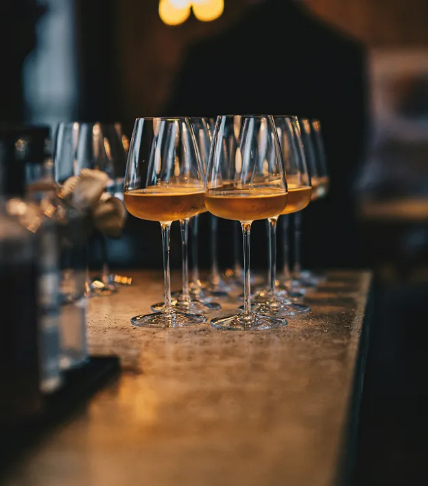 Un tavolo con sopra tanti calici di vino bianco